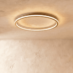 Close view of the Clérachic gold ceiling ring, showing the slim metal band and its warm LED edge glow.