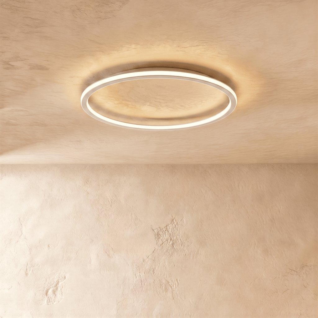 A side angle of the Clérachic white ceiling ring, showing its slim profile and soft warm glow along the rim.