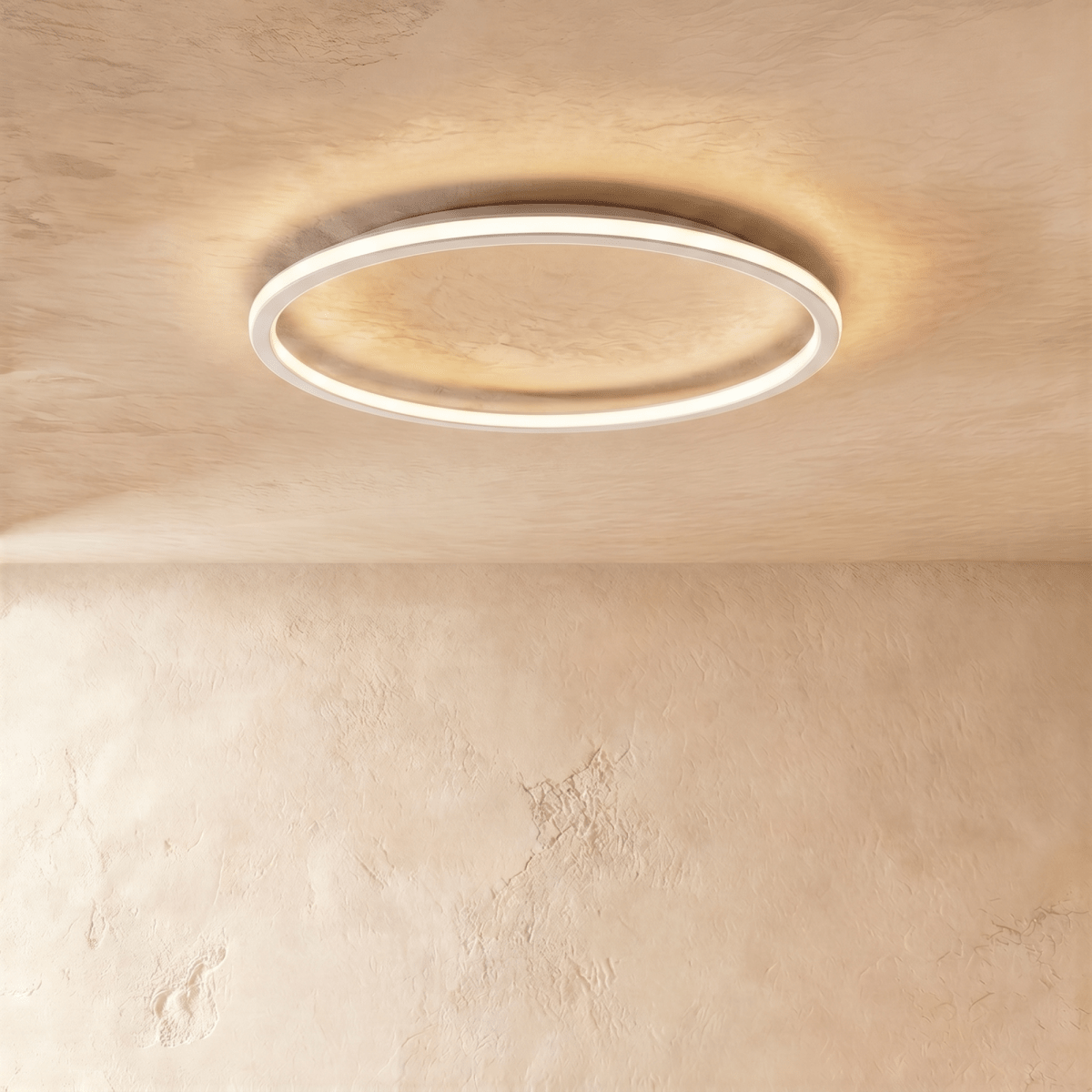 Close view of the Clérachic white ceiling ring, its slim frame lit warm white against a plaster ceiling.