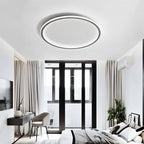 The Clérachic matte black ceiling ring lights a bedroom with dark-framed balcony doors and sheer curtains.