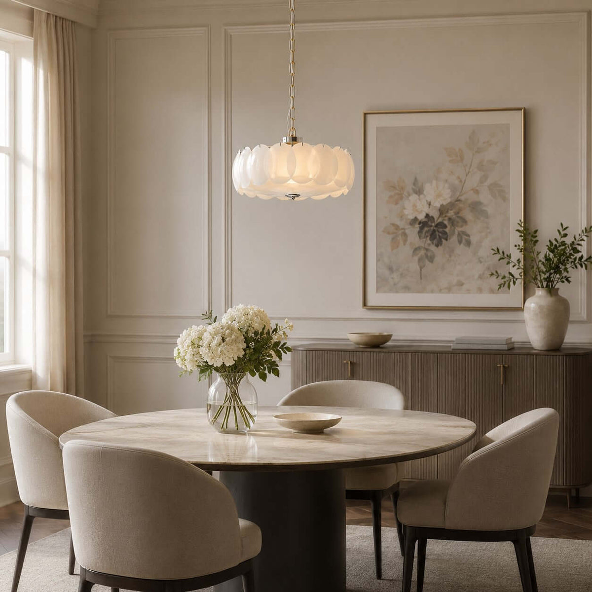 Hung low above a round dining table and four curved chairs, this Clérachic chandelier lights a cream panelled room with a floral print.