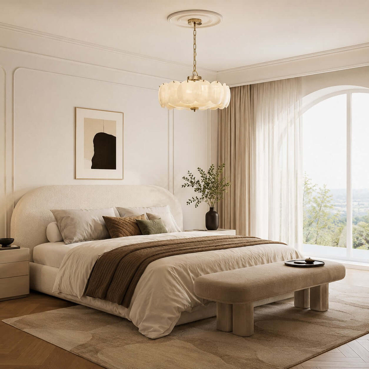 In a bedroom with a cream upholstered bed and arched window, a Clérachic chandelier hangs from a plaster ceiling rose on a brass chain.