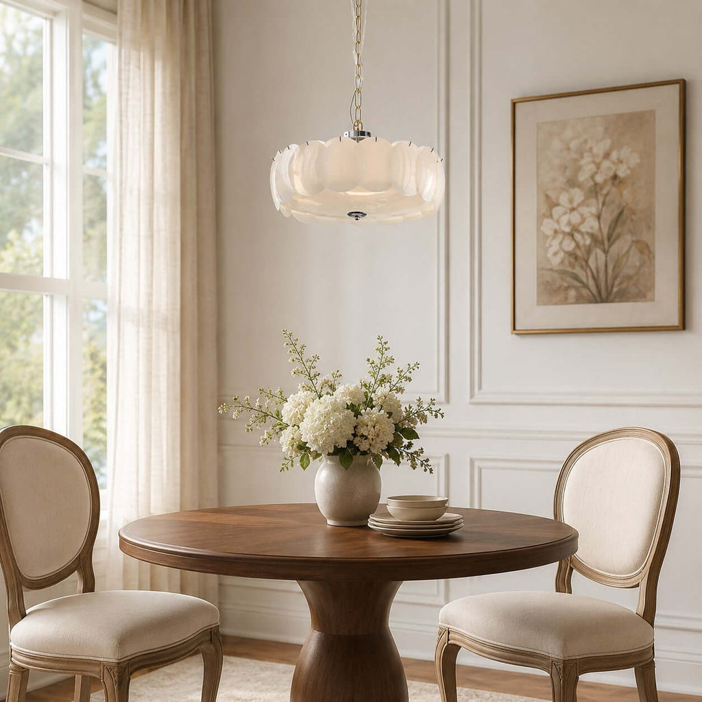 Close to a tall sash window, a Clérachic chandelier of white glass discs hangs over a round walnut table and two oval-backed chairs.