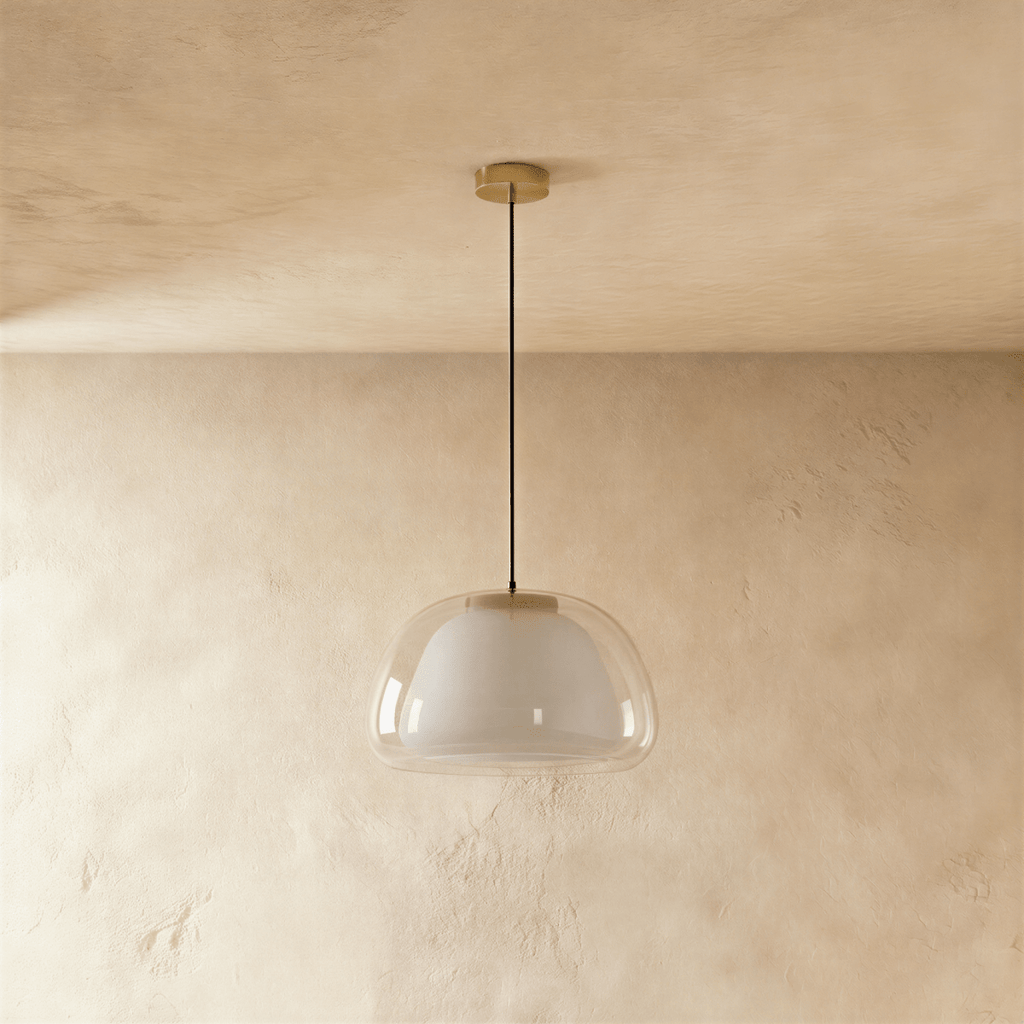Clérachic pendant light, unlit, showing a clear glass outer shade over a white opal diffuser on a thin black cord and brass canopy.