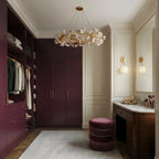 Clérachic round chandelier hanging in a dressing room with plum wardrobes, a velvet pouf and two globe wall lights.