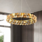 An amber Clérachic chandelier lit in a corner room with a tall window and grey vertical-slat curtains.