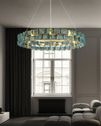 Blue ribbed glass blades glow on this Clérachic chandelier, hung high in a grey room with a tall window and a black radiator.