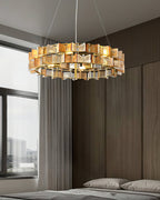 In a bedroom with wood-panelled walls and a grey bed, this amber Clérachic chandelier lights the room from a high ceiling.