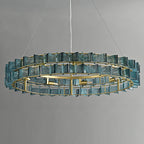 Straight-on view of a blue Clérachic chandelier on a grey backdrop, two tiers of ribbed glass around a brass ring with its bulbs visible.