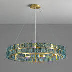 Lit blue Clérachic chandelier on a grey backdrop, its brass ring and spaced bulbs visible beneath two rows of ribbed glass.