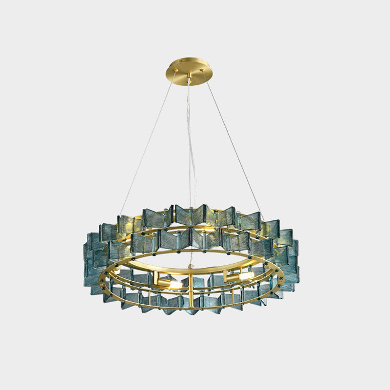 A blue Clérachic chandelier shown small on a pale backdrop, hanging from a brass canopy by three wires.