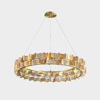 A Clérachic chandelier in amber on light grey, hung from a gold canopy, its bulbs lit inside the ring of ribbed glass.