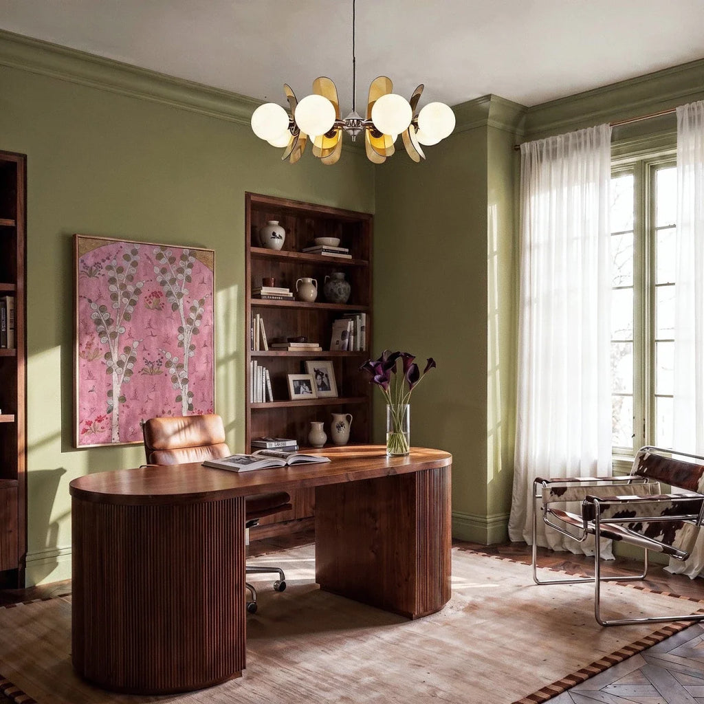 Clérachic chandelier with amber petals and white globes hung in an olive green study over a walnut desk