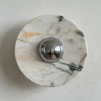 Cream stone with soft gold clouds and fine grey-green veins makes up this Clérachic marble wall light, shown from the front.