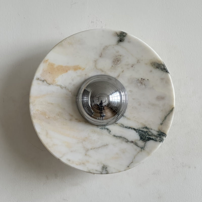 Cream stone with soft gold clouds and fine grey-green veins makes up this Clérachic marble wall light, shown from the front.