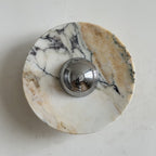 Across this Clérachic marble wall light runs a bold gold band with purple-black veining, around a chrome dome in the middle.