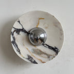 A Clérachic marble wall light with dark purple-black veins spreading across a bright white disc, and a chrome dome at its centre.