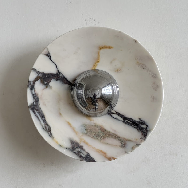A Clérachic marble wall light with dark purple-black veins spreading across a bright white disc, and a chrome dome at its centre.