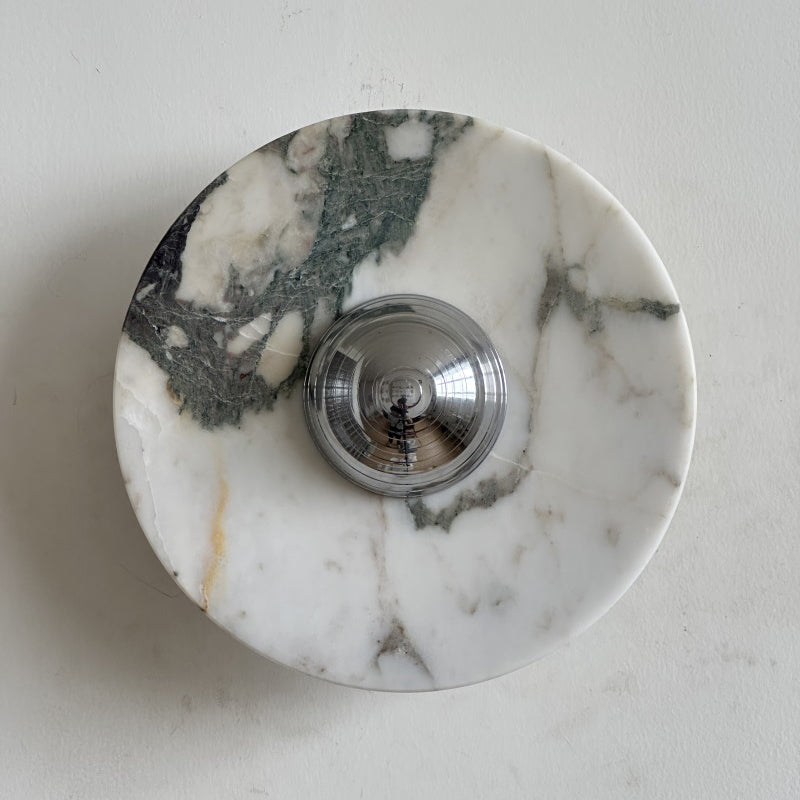 White stone with a green-grey mossy patch at upper left and fine grey veins elsewhere makes up this Clérachic round marble wall light.
