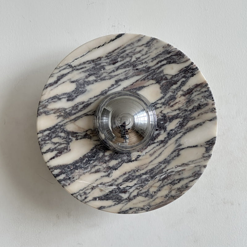 A Clérachic marble wall light with long streaky grey-purple veins on a cream ground, with a polished chrome dome at its middle.