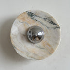 Fine, brushed purple-grey streaks run across the pale disc of this Clérachic marble wall light, with a chrome dome at its centre.