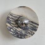 A Clérachic marble wall light with fine, brushed purple-grey streaks across a pale disc, with a chrome dome at its centre.