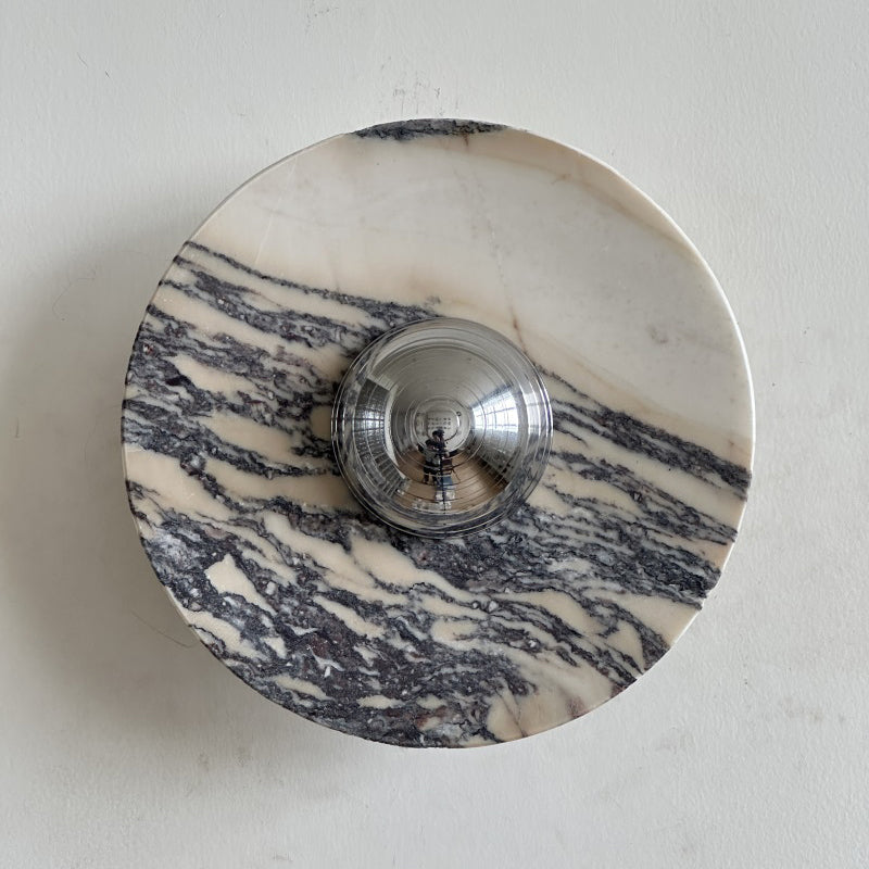 A Clérachic marble wall light with fine, brushed purple-grey streaks across a pale disc, with a chrome dome at its centre.