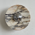 One dark vein climbs from lower left to upper right across the pale grey-white stone of this Clérachic marble wall light.