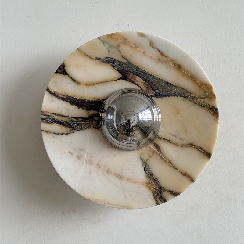 A Clérachic marble wall light in warm cream stone with thick gold and dark brown ribbons crossing its face, around a chrome dome.