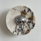 Clean cream stone with a web of black and gold veins spreads out from the chrome dome of this Clérachic marble wall light.