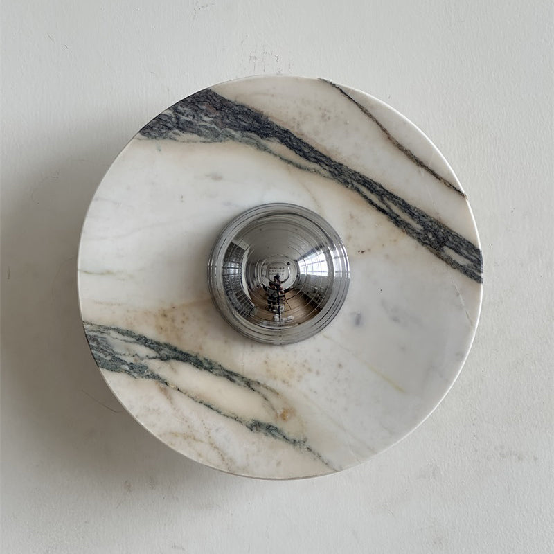A Clérachic marble wall light with a long dark vein across the upper right and pale pink-grey stone around the chrome dome.