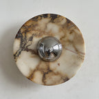 Clean white stone with soft gold and grey veins forms this Clérachic marble wall light, its chrome dome catching the light.