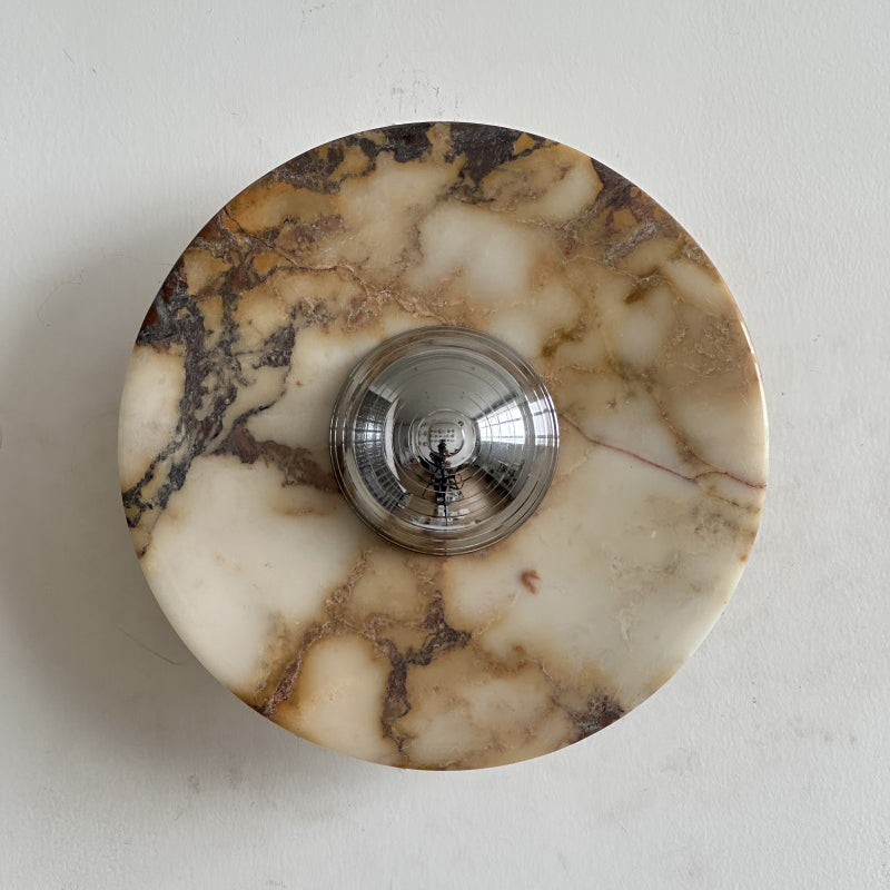 Clean white stone with soft gold and grey veins forms this Clérachic marble wall light, its chrome dome catching the light.