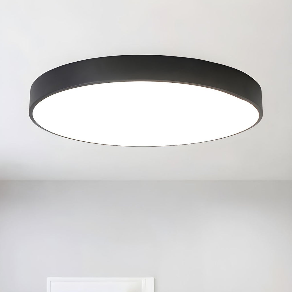 Black-framed round Clérachic LED ceiling light seen from below, with an even white glow across the diffuser.