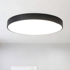 Black-framed round Clérachic LED ceiling light seen from below, with an even white glow across the diffuser.