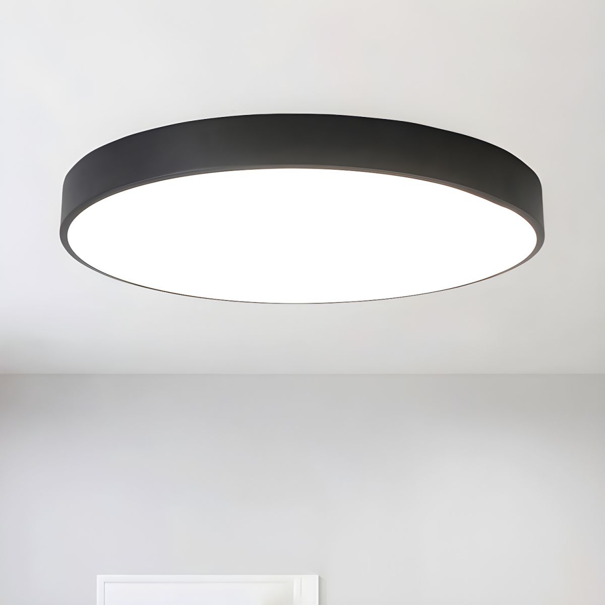 Black-framed round Clérachic LED ceiling light seen from below, with an even white glow across the diffuser.