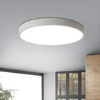 White round Clérachic ceiling light lit on a grey ceiling, with a window and a glass-fronted cabinet below.