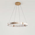 A Clérachic travertine ring pendant on a wooden ceiling plate, with three fine suspension cables, against a pale grey wall.