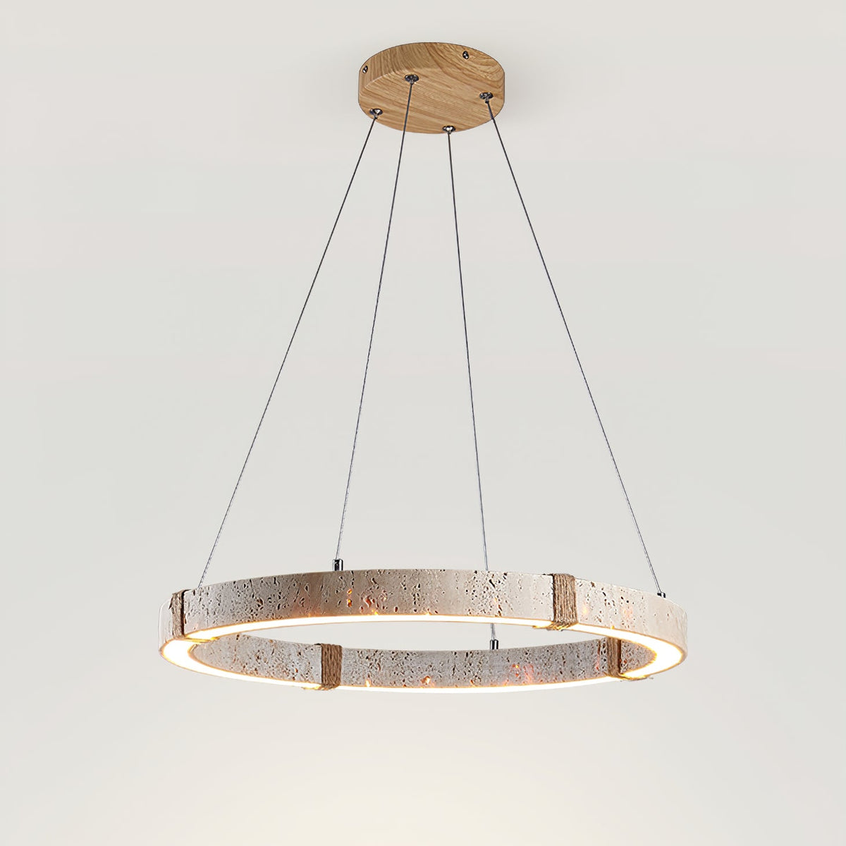 Travertine ring pendant from Clérachic seen at a lower angle, with a glowing inner edge and four rope-wrapped joints.