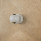 Clérachic round white wall sconce with clear lenses, switched off, mounted flat on a limewashed wall