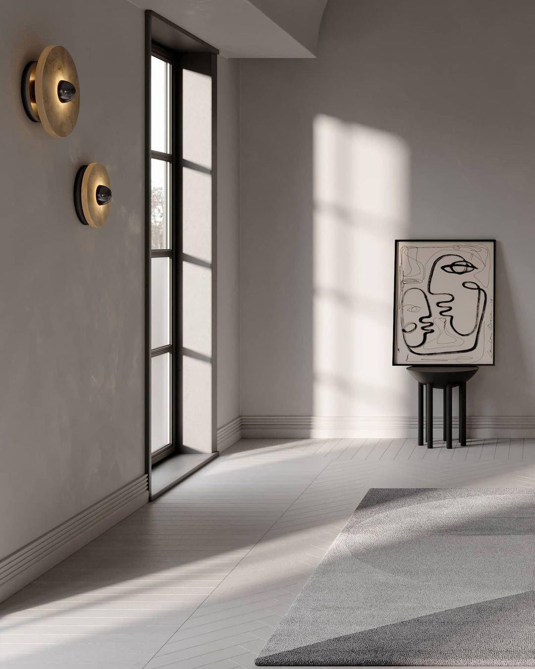 Clérachic round alabaster sconces on a plaster wall in a sunlit hall with a black window.