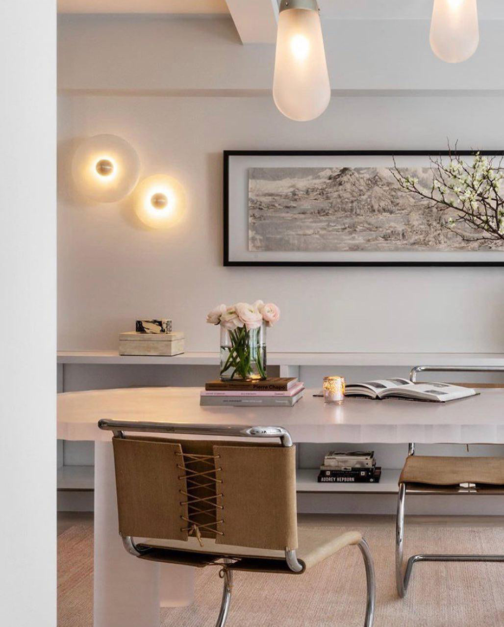 Clérachic round alabaster sconces on a white wall above a desk and cane-backed chair.
