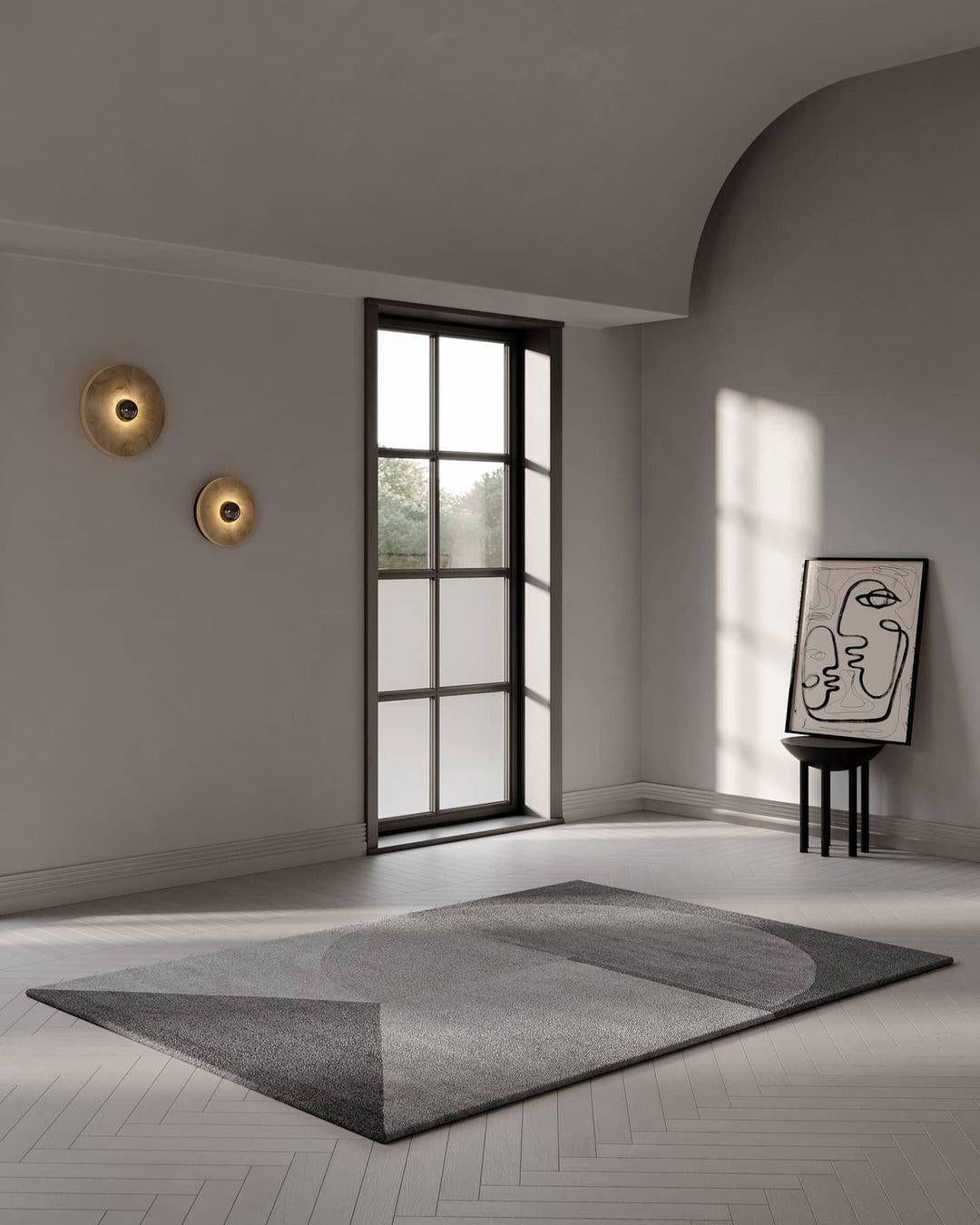 Two Clérachic round alabaster sconces on a white wall in a room with a herringbone floor.