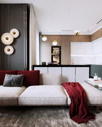 Clérachic round alabaster sconces on a dark panel in an open-plan kitchen and lounge.