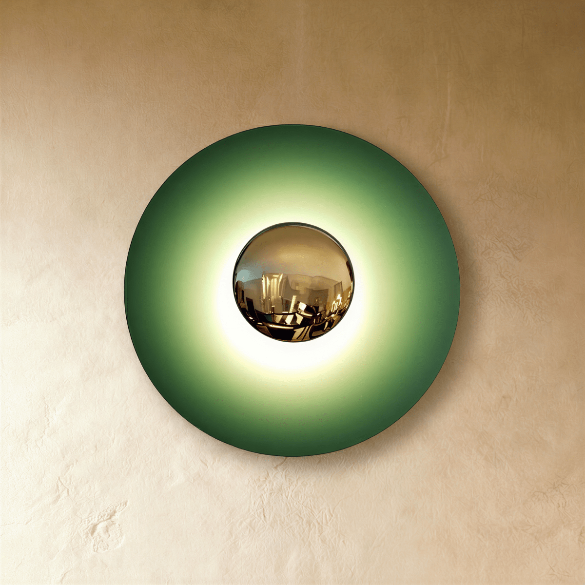 Clérachic round wall lamp in studio light with a deep green disc fading to a bright glow around its brass mirror dome.