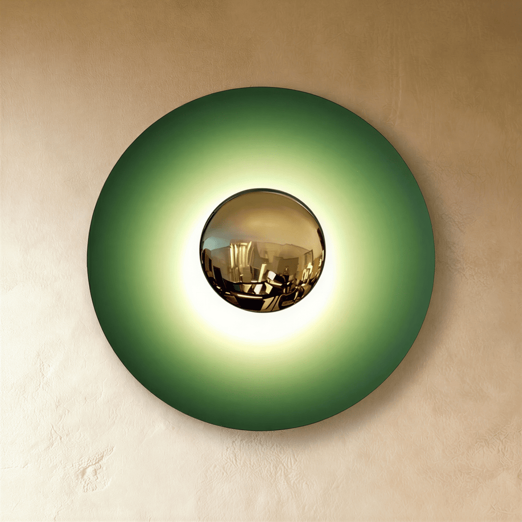 Clérachic larger round wall lamp in studio light with a green disc, a brass mirror dome and a bright glow at the centre.