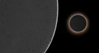 Close view of the pitted dark cement surface of this Clérachic round wall light, with a second one glowing beyond it.