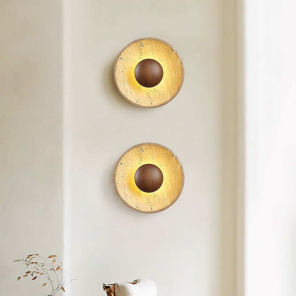 Two Clérachic travertine wall lights with walnut domes, stacked one above the other on a cream wall and lit warm.