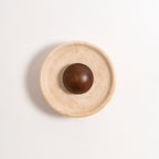 Unlit Clérachic travertine wall light with a walnut dome, shown straight on against a white wall with a soft shadow.