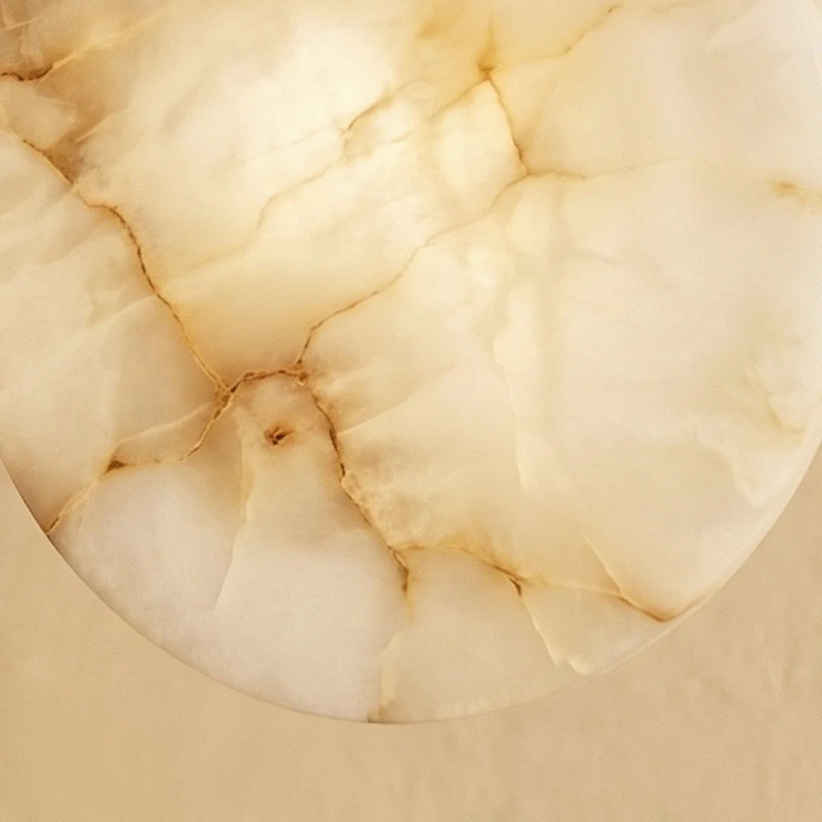 Clérachic close view of the alabaster disc, its cream stone and amber veining filling the frame.